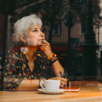 women daydreaming inside a coffee shop