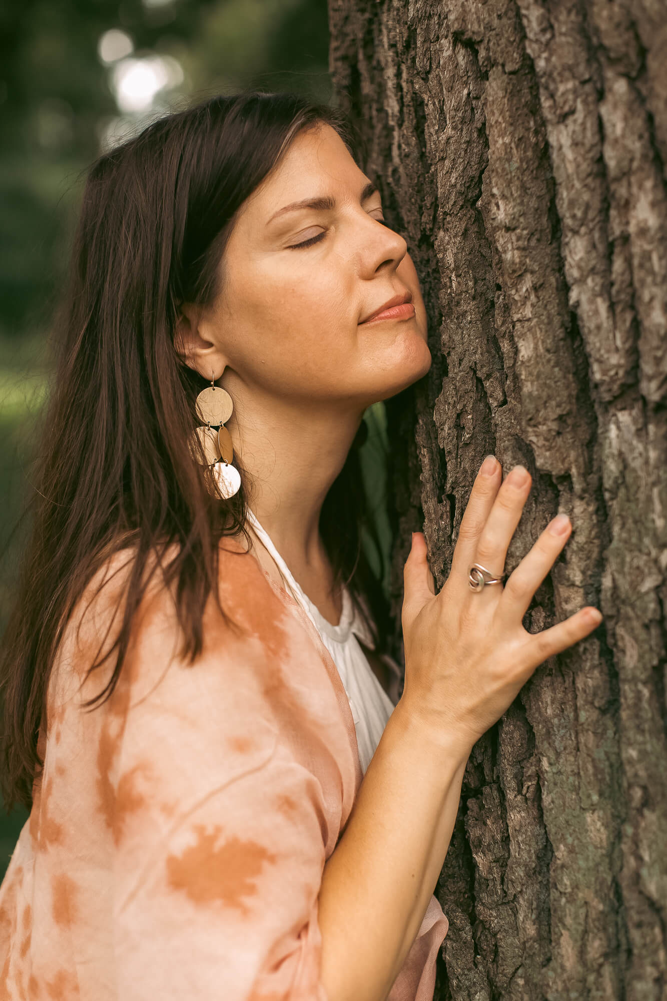 Kristi leaning into a pine tree